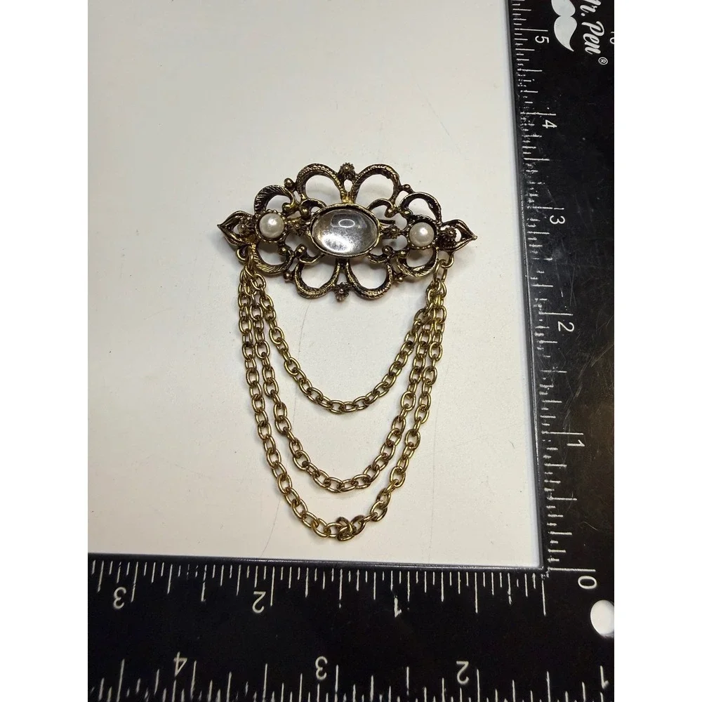 Ornate Gold Tone Filigree Brooch Faux Pearls Clear Cabochon and Triple Chain